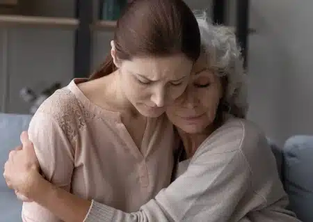 older woman hugging younger woman